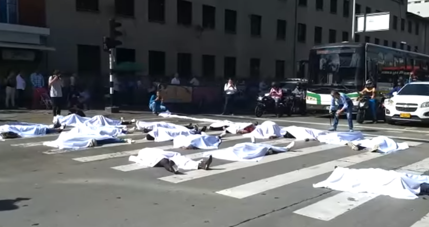 [Video] Tras aumento en homicidios, jóvenes protestan tendidos en la carretera y con una sábana blanca sobre su cuerpo