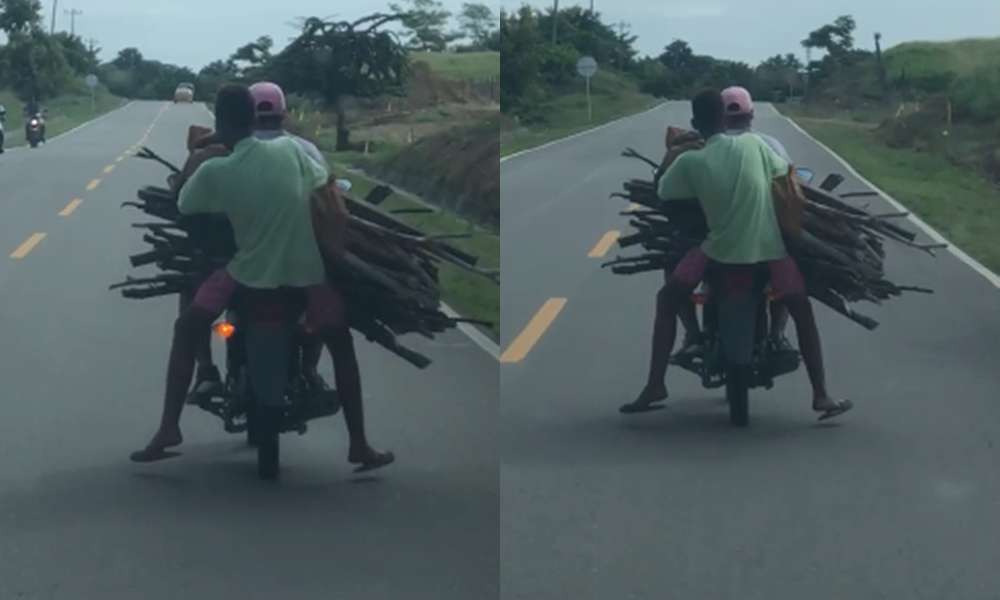 Qué peligro, dos jóvenes transportan excesiva carga de madera en una moto